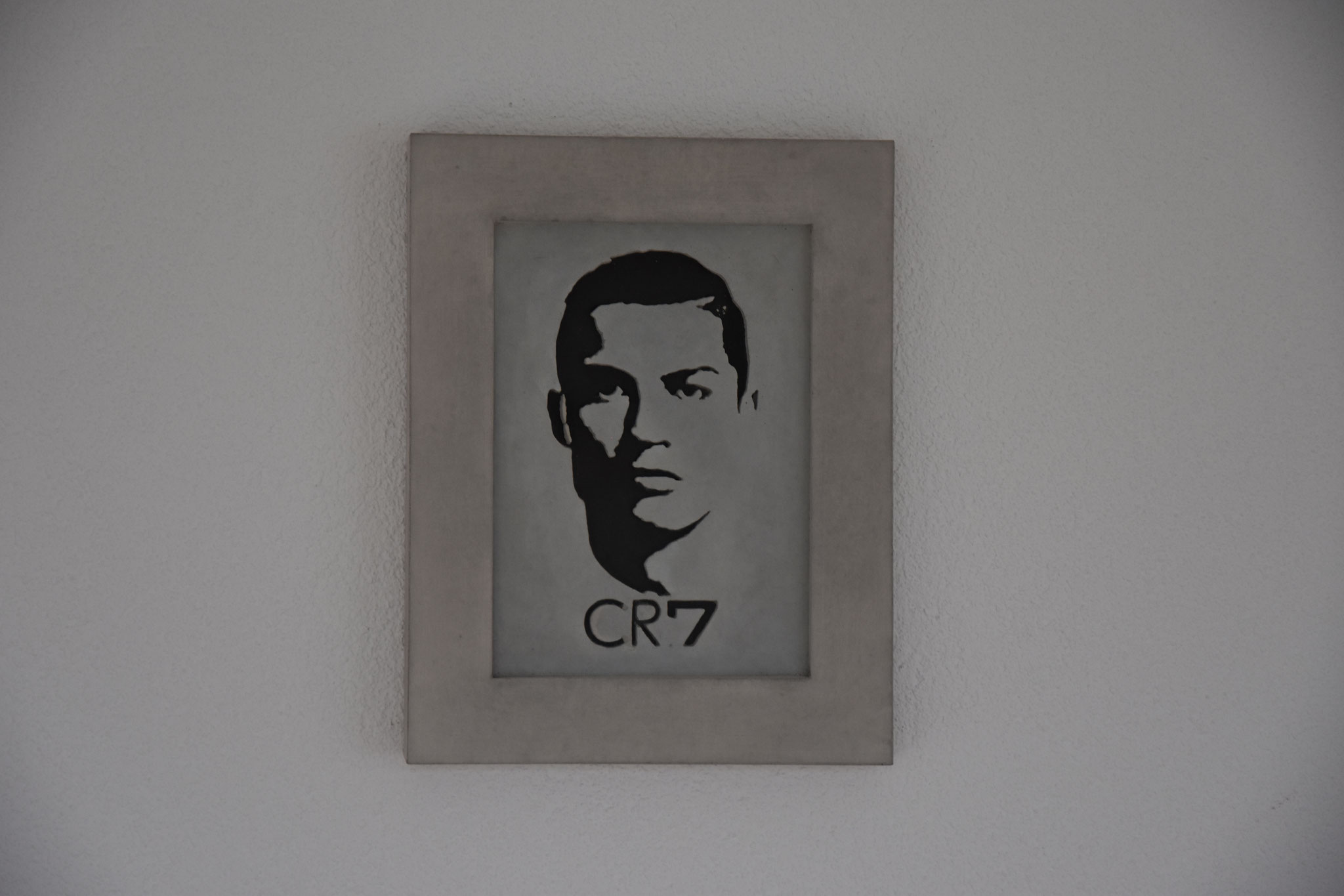 Betonportrait von Cristiano Ronaldo mit seinem ikonischen Kürzel ‚CR7‘, minimalistisch auf grauem Hintergrund gestaltet.